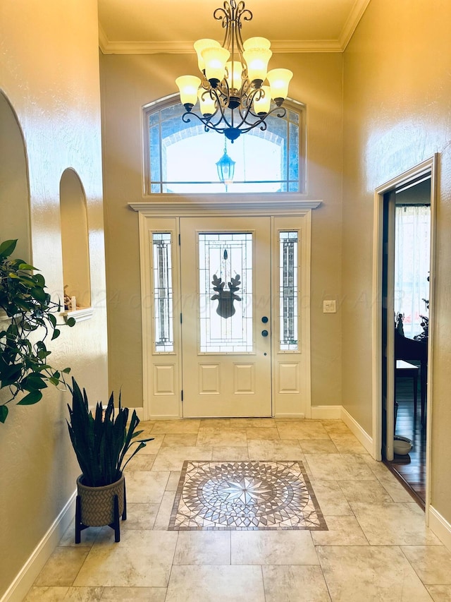 entrance foyer with a chandelier, a high ceiling, and ornamental molding