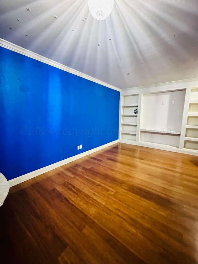 additional living space featuring wood-type flooring, a textured ceiling, and built in features