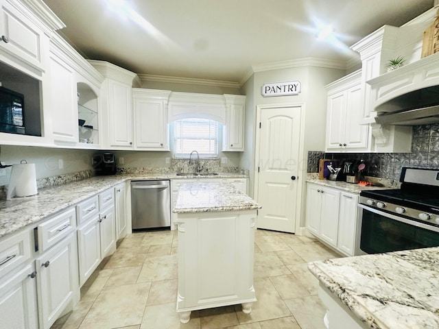 901 Melinda Ln, Dumas, TX 79029 - kitchen featuring appliances with stainless steel finishes, white cabinets, crown molding, decorative backsplash, and a center island