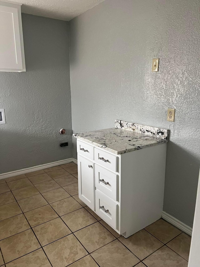 laundry room featuring light tile patterned flooring and baseboards