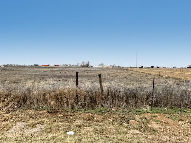 view of yard with fence and a rural view