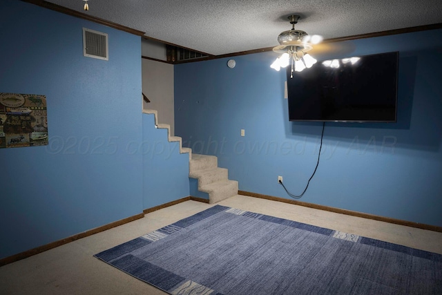 basement with ornamental molding, carpet flooring, and a textured ceiling