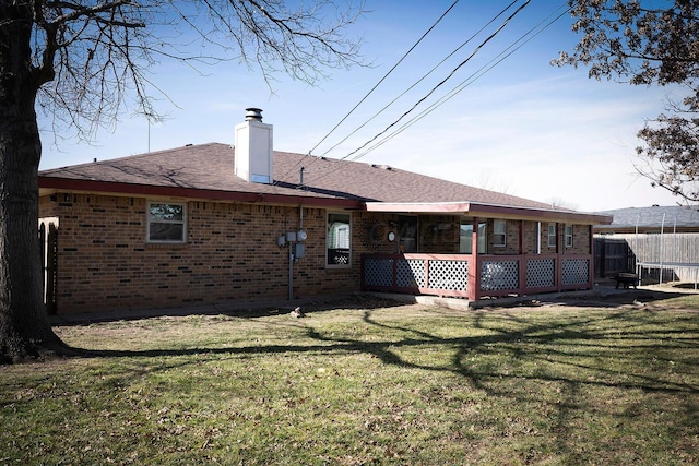 rear view of house featuring a yard