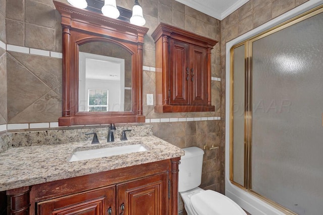 bathroom featuring tile walls, crown molding, vanity, and toilet