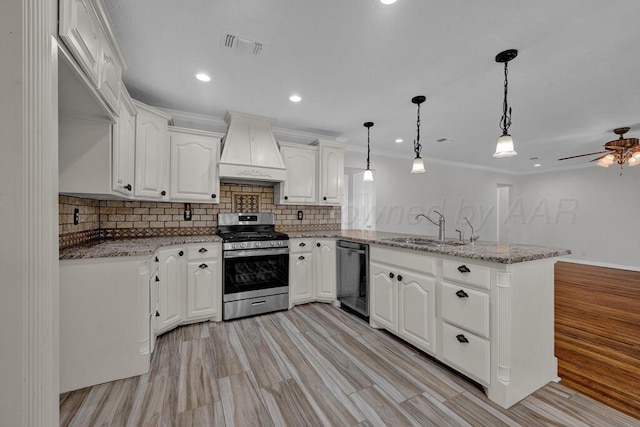 kitchen featuring stainless steel range with gas cooktop, custom exhaust hood, dishwasher, a peninsula, and a sink