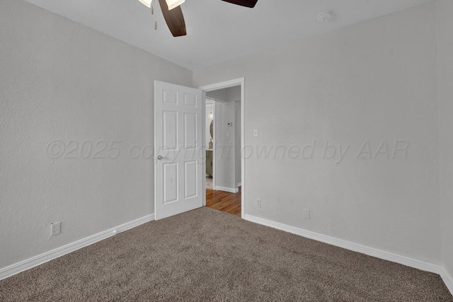 empty room with a ceiling fan, carpet flooring, baseboards, and a smoke detector