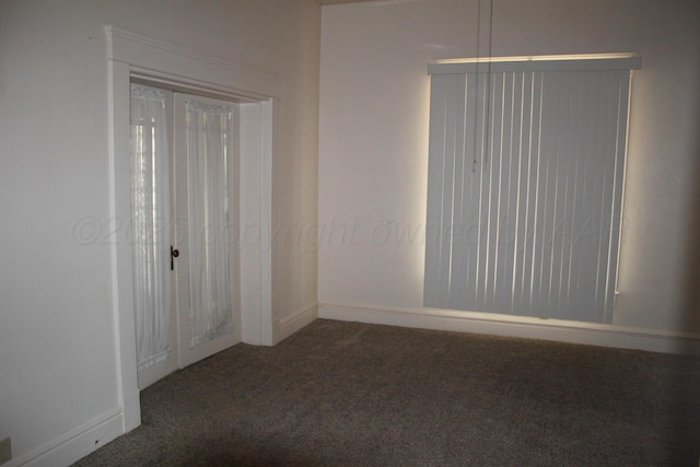 unfurnished room with carpet and baseboards