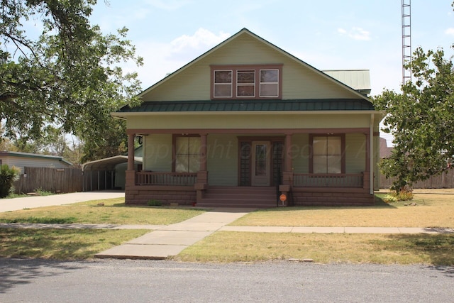 bungalow-style home featuring metal roof, a porch, fence, a standing seam roof, and a front yard