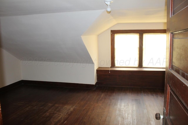 bonus room with lofted ceiling, baseboards, and dark wood-type flooring