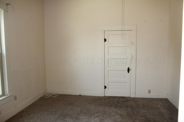 carpeted empty room featuring baseboards