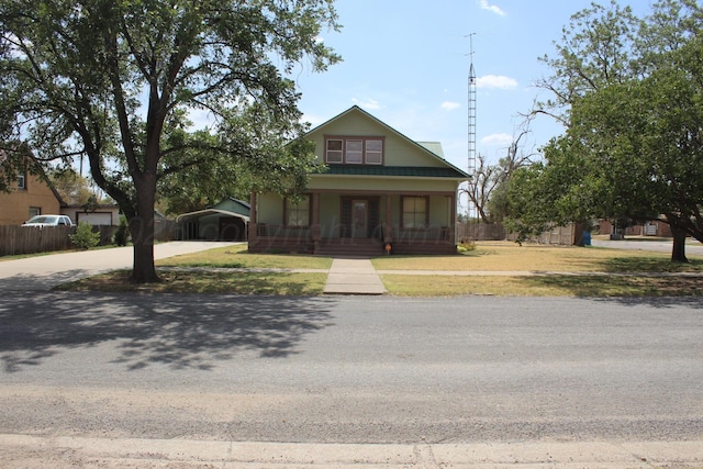 bungalow-style home with covered porch, fence, and a front yard