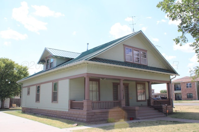 view of front facade with covered porch, metal roof, and a standing seam roof