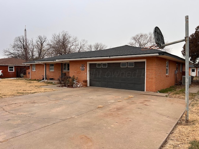 ranch-style house with a garage and central AC unit