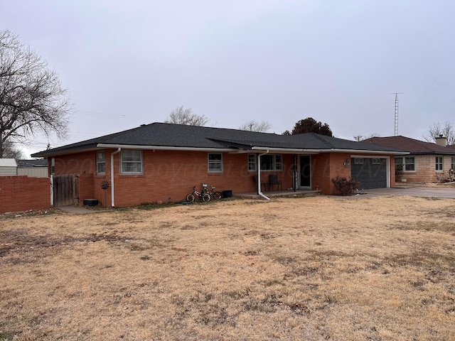 rear view of property with a garage and a yard