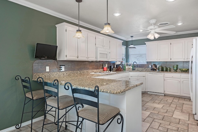 kitchen with white appliances, kitchen peninsula, a kitchen bar, white cabinetry, and backsplash