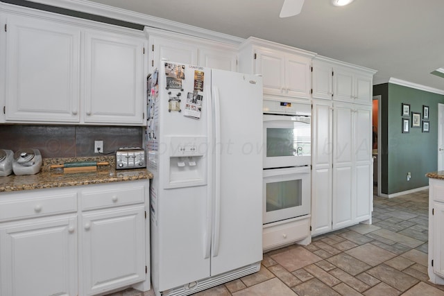 kitchen with white cabinets, white appliances, ornamental molding, ceiling fan, and dark stone counters