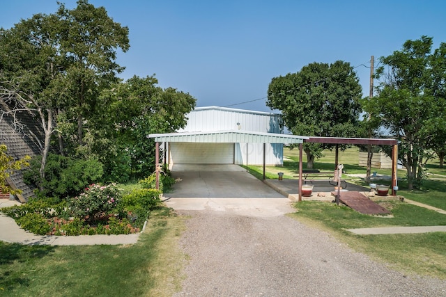 view of front of property featuring a carport, a front yard, a garage, and an outdoor structure