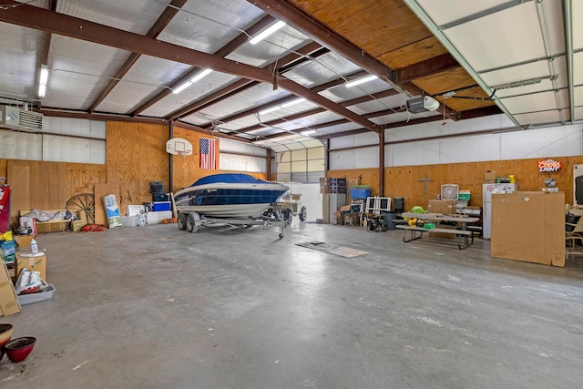 garage with a garage door opener, wood walls, and white fridge