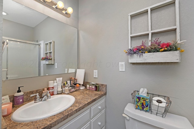 bathroom with walk in shower, vanity, and toilet