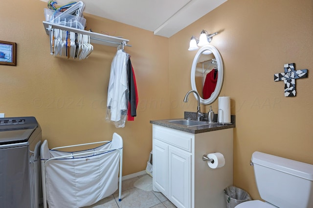 bathroom featuring toilet, washer / dryer, tile patterned flooring, and vanity