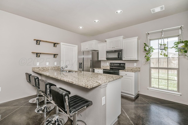 303 Loesh St, Amarillo, TX 79118 - kitchen featuring black appliances, a breakfast bar, a peninsula, white cabinetry, and recessed lighting