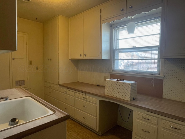 kitchen with tasteful backsplash, sink, and hanging light fixtures