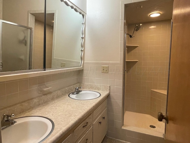 bathroom with vanity, tile walls, and tiled shower