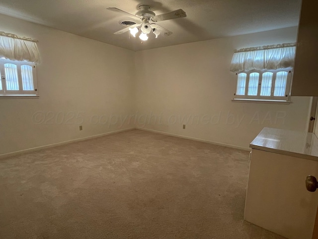 unfurnished room with ceiling fan and light colored carpet