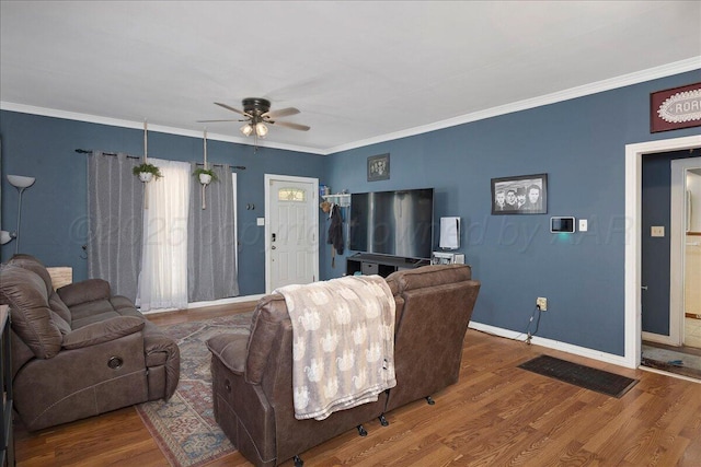living room with ceiling fan, baseboards, crown molding, and wood finished floors