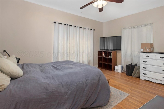 bedroom with light wood-style flooring and a ceiling fan