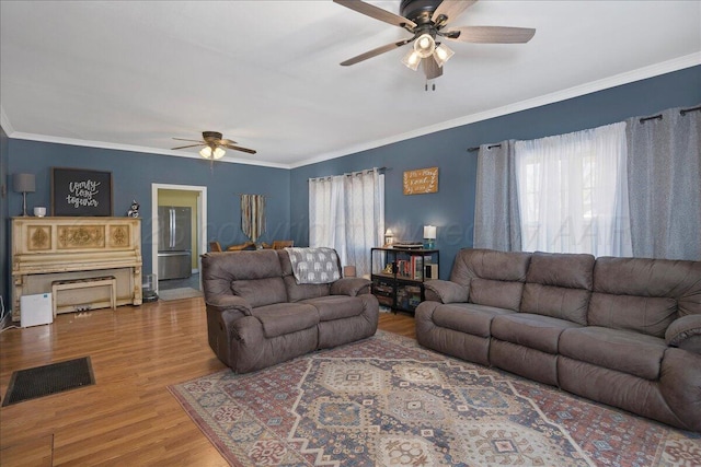 living area featuring crown molding, visible vents, a ceiling fan, and wood finished floors