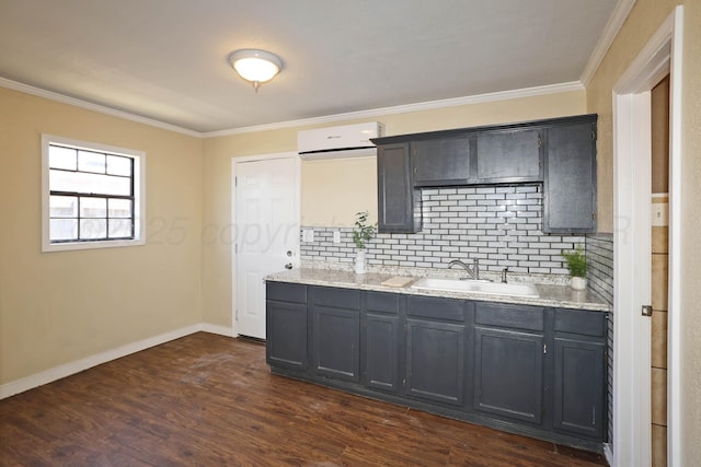 kitchen featuring ornamental molding, dark wood-style flooring, an AC wall unit, a sink, and backsplash