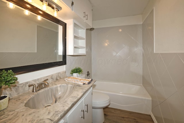 bathroom featuring vanity, shower / bathtub combination, wood finished floors, toilet, and tile walls