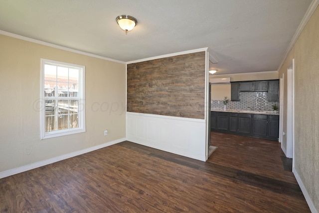 spare room featuring crown molding, wainscoting, a wall mounted air conditioner, and dark wood-type flooring