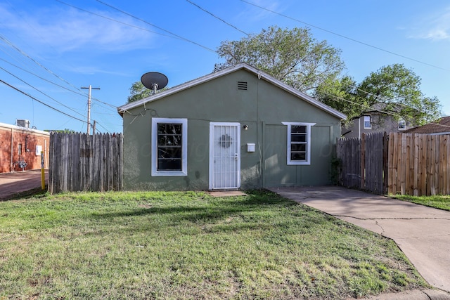 bungalow-style house featuring fence, stucco siding, and a front yard