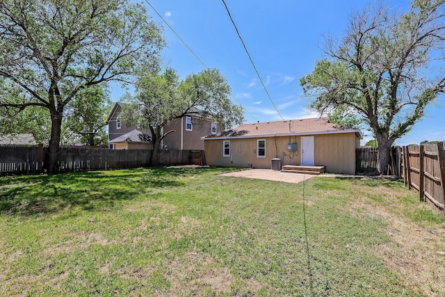 rear view of house featuring a fenced backyard, a patio, and a yard