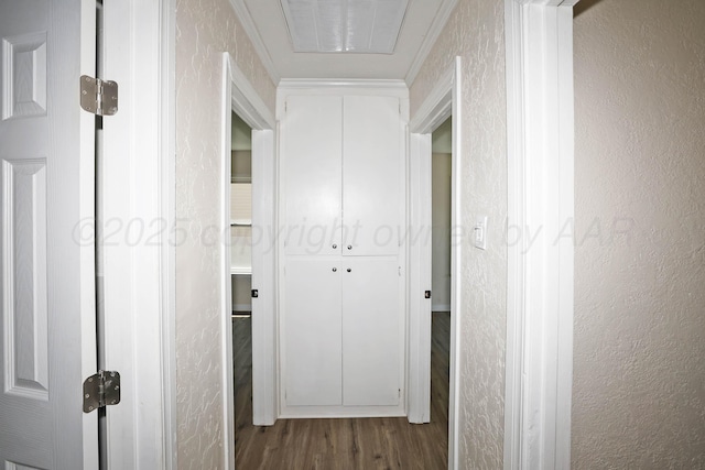 hall with visible vents, dark wood finished floors, and a textured wall