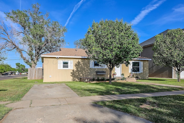 view of front of house featuring stucco siding and a front yard