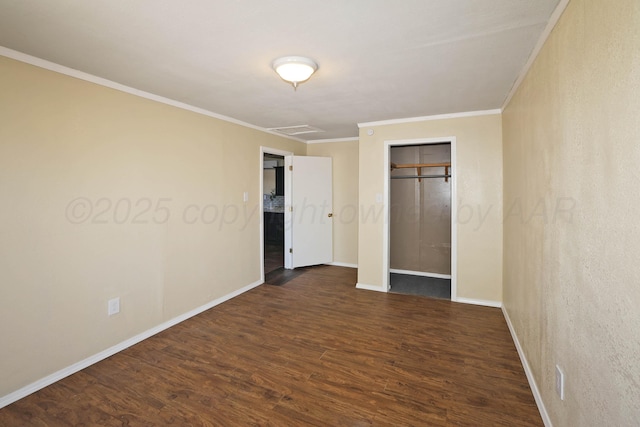 unfurnished bedroom with crown molding, baseboards, attic access, and dark wood-type flooring