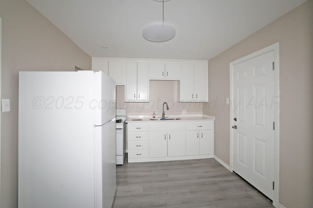 4112 S Tyler St, Amarillo, TX 79110 - kitchen with white appliances, light countertops, light wood-type flooring, white cabinetry, and pendant lighting