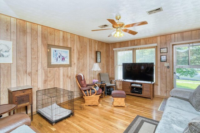 1909 N Wells St, Pampa, TX 79065 - living room with wood walls, ceiling fan, and wood finished floors
