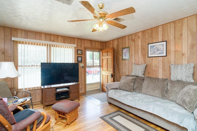1909 N Wells St, Pampa, TX 79065 - living room with wood walls, light wood-style floors, and ceiling fan
