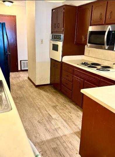 kitchen featuring white appliances and light wood-type flooring