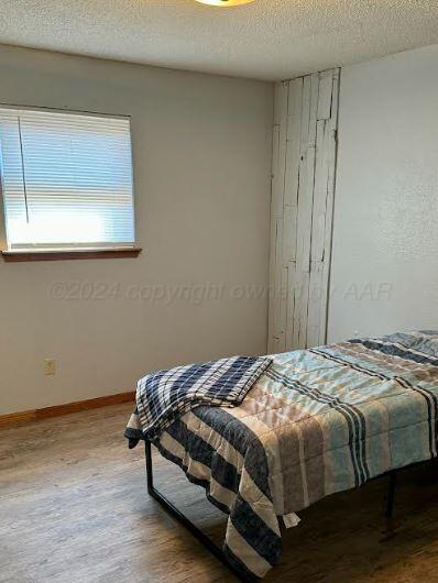 bedroom with hardwood / wood-style floors and a textured ceiling