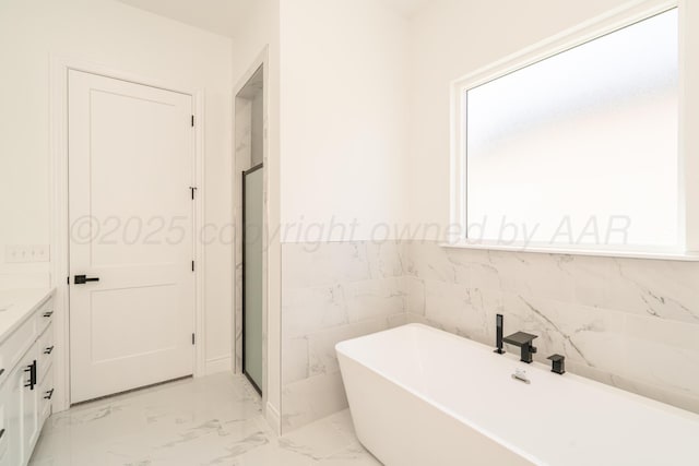 2909 Daytona Ave, Amarillo, TX 79118 - bathroom featuring a soaking tub, marble look tile flooring, vanity, and a stall shower