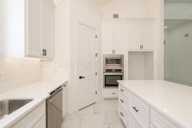 2909 Daytona Ave, Amarillo, TX 79118 - kitchen with stainless steel appliances, light marble finish floors, white cabinetry, backsplash, and vaulted ceiling