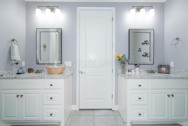 bathroom with a sink, baseboards, tile patterned flooring, and two vanities