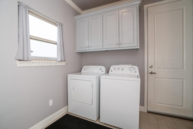 laundry room featuring baseboards, ornamental molding, cabinet space, and independent washer and dryer
