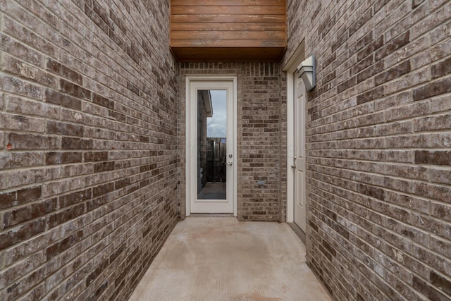 doorway to property featuring brick siding
