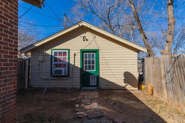 view of outdoor structure with fence and cooling unit